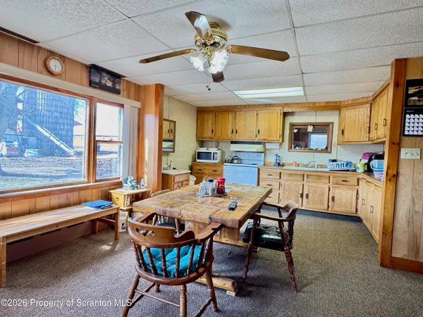 a dining room with a table chairs and a kitchen view