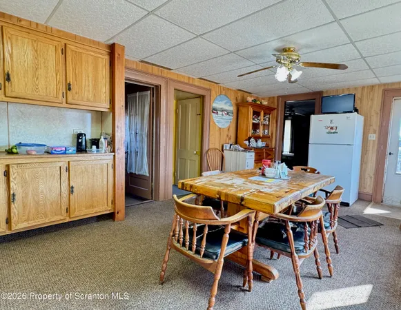 a dining room with stainless steel appliances a table chairs and chandelier