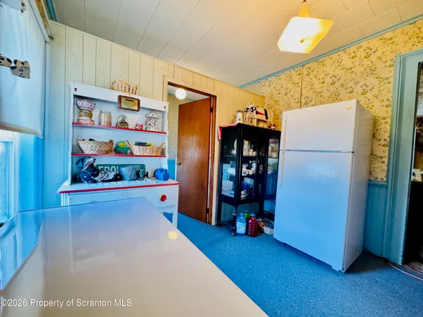 a kitchen with stainless steel appliances a refrigerator and a wooden floor