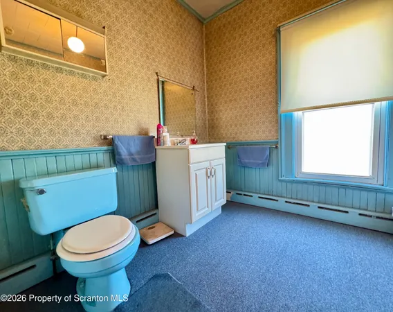 a bathroom with a toilet a sink and a window