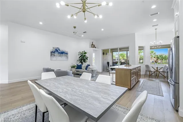 a living room with furniture kitchen view and a chandelier