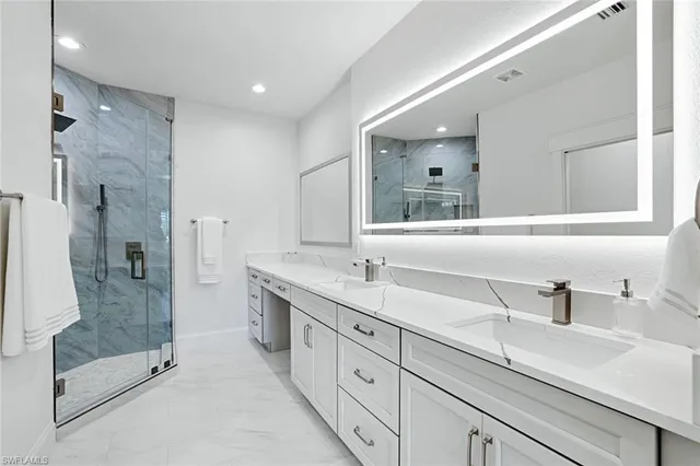 a bathroom with a double vanity sink mirror and shower