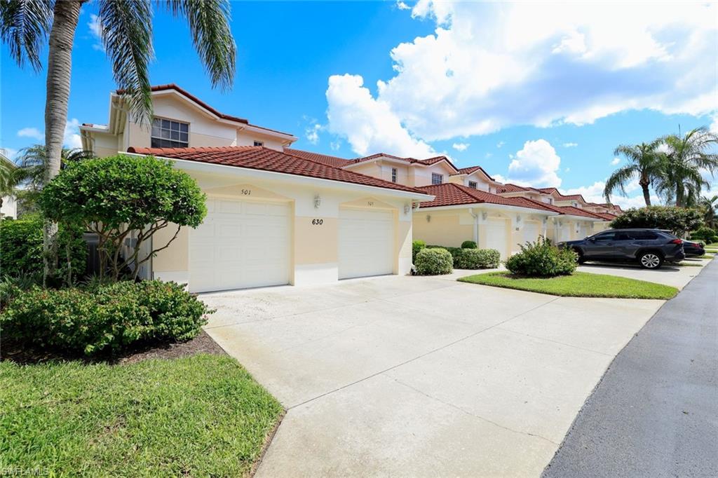 630 Lalique Circle, Unit 506 Naples, FL 34119 - Photo 2 of 25 a view of a house with a yard and potted plants