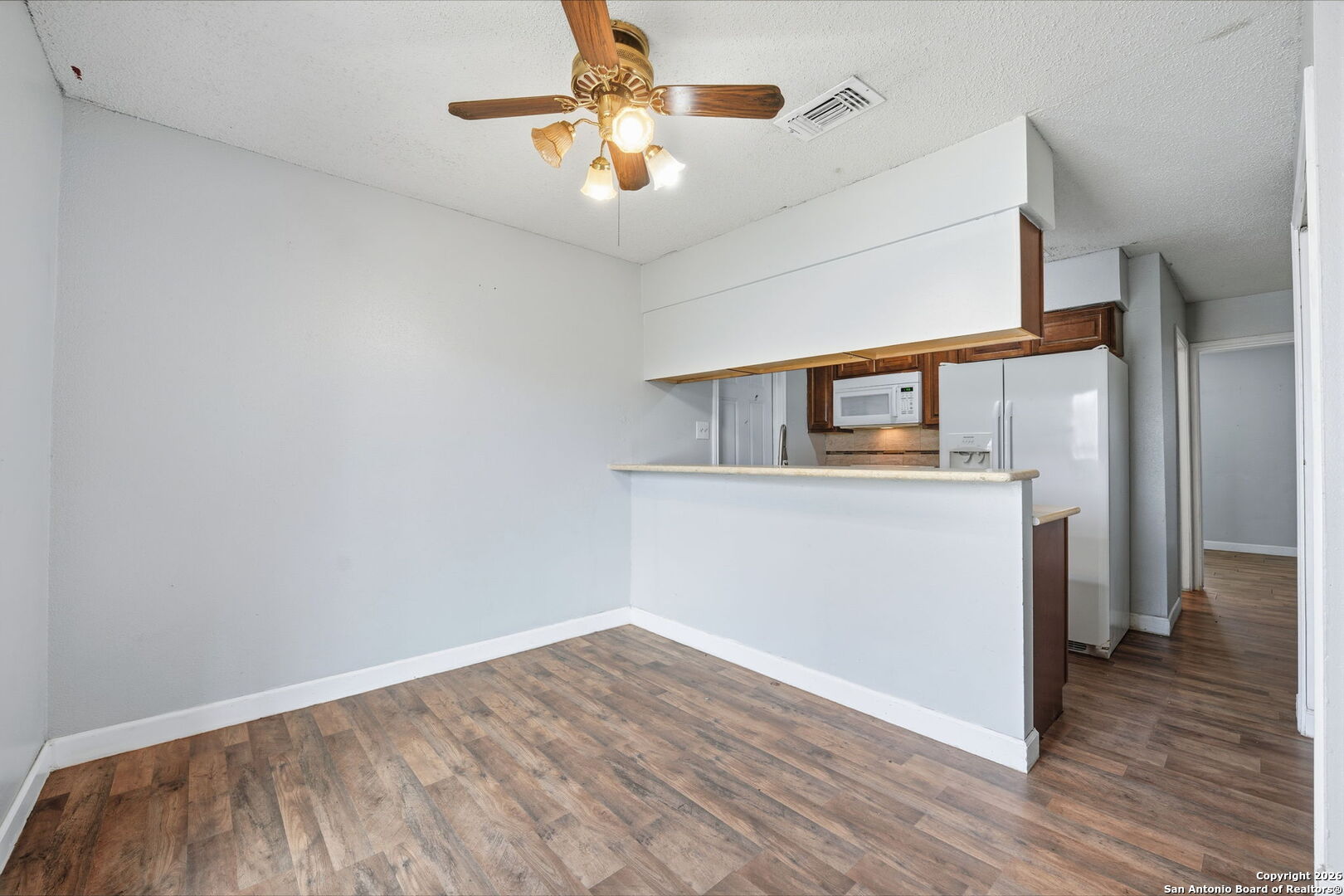 126 Meadow Way Converse, TX 78109 - Photo 13 of 33 a view of a kitchen with wooden floor and a ceiling fan