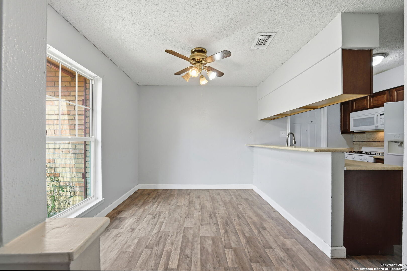 126 Meadow Way Converse, TX 78109 - Photo 14 of 33 wooden floor in an empty room with a window