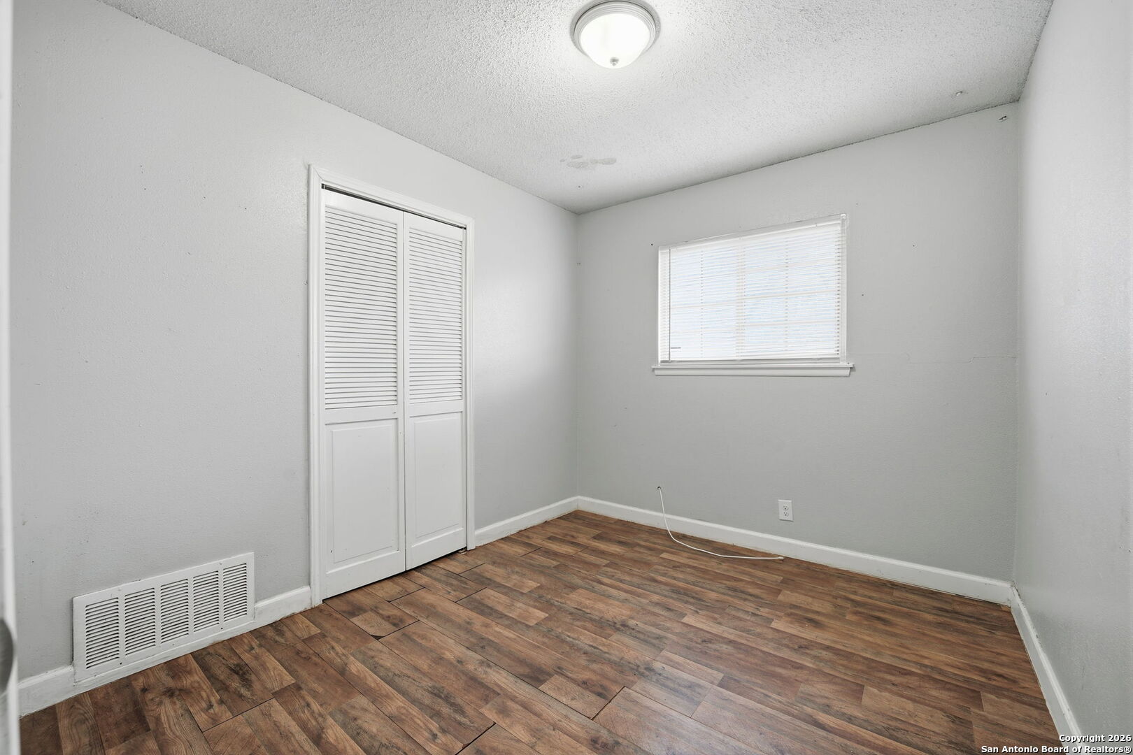 126 Meadow Way Converse, TX 78109 - Photo 23 of 33 an empty room with wooden floor and windows