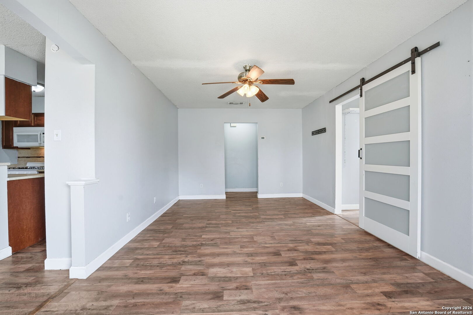 126 Meadow Way Converse, TX 78109 - Photo 8 of 33 a view of empty room with wooden floor and ceiling fan