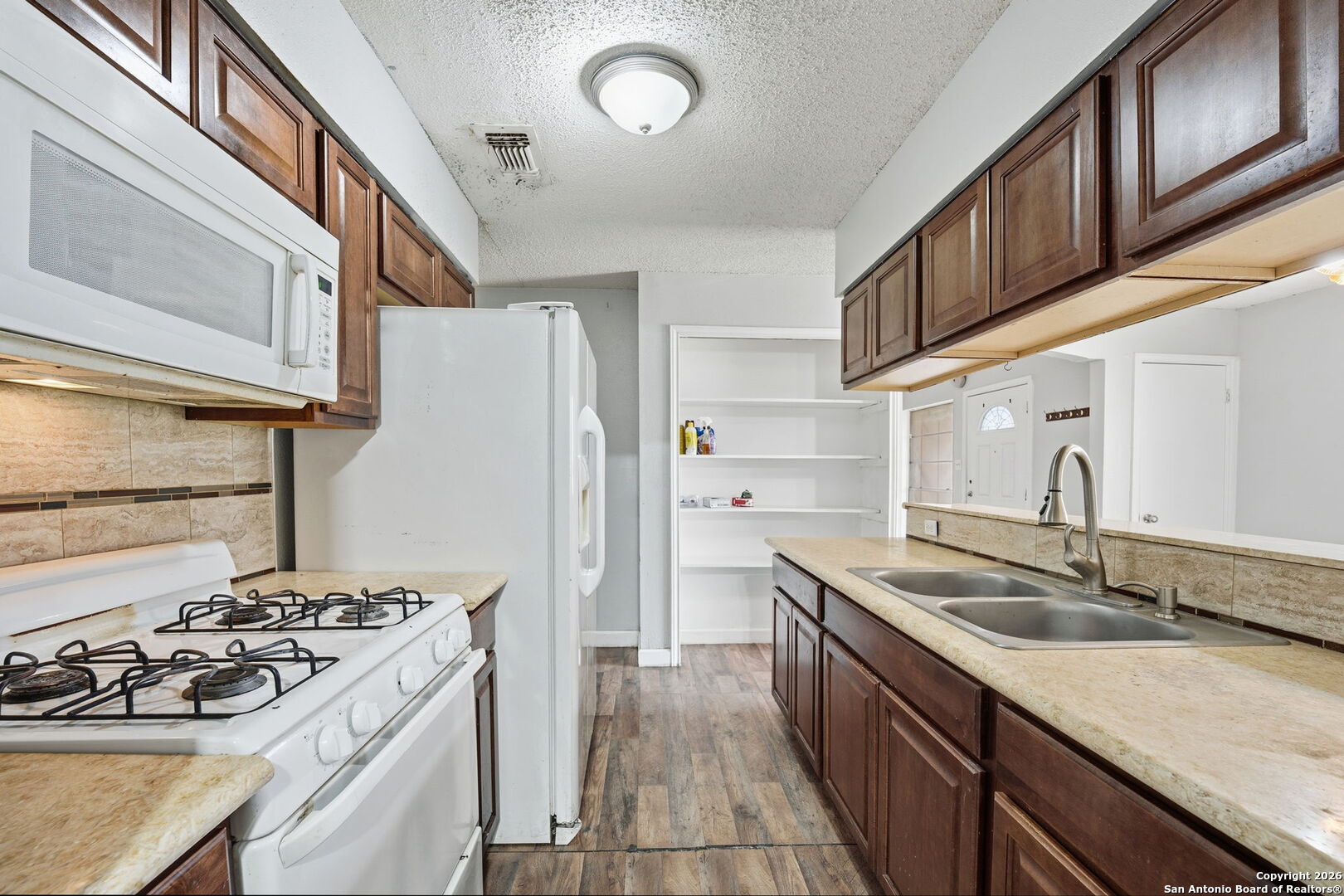 126 Meadow Way Converse, TX 78109 - Photo 9 of 33 a kitchen with a sink stove and refrigerator
