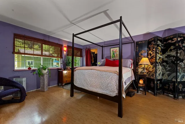 a view of a hallway with wooden floor and a bathroom