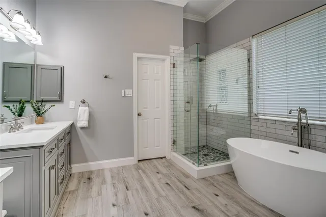 a bathroom with a bathtub a mirror a sink and shower