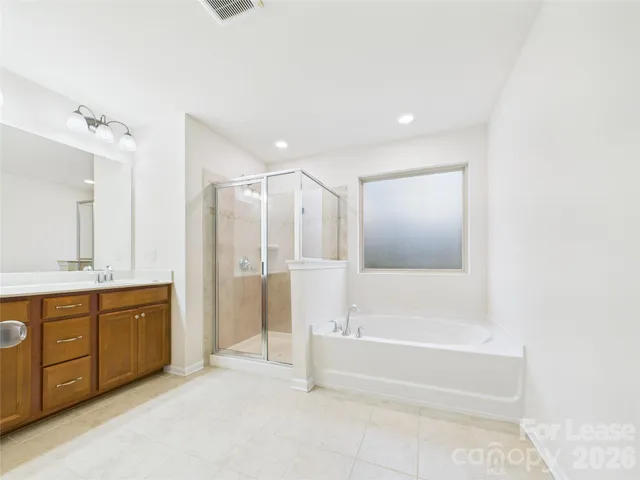 a spacious bathroom with a tub shower and sink