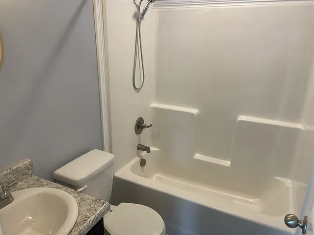 a white toilet sitting next to a bathroom sink and tub