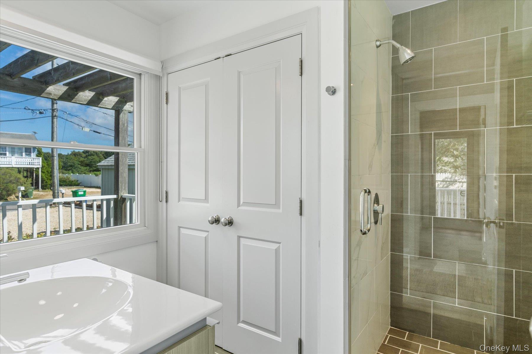 4415 Camp Mineola Road Mattituck, NY 11952 - Photo 18 of 44 a bathroom with a shower and a sink