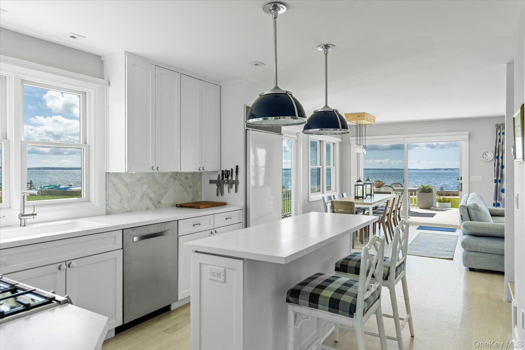 4415 Camp Mineola Road Mattituck, NY 11952 - Photo 6 of 44 a kitchen with stainless steel appliances granite countertop a stove a sink a refrigerator a dining table and chairs with wooden floor