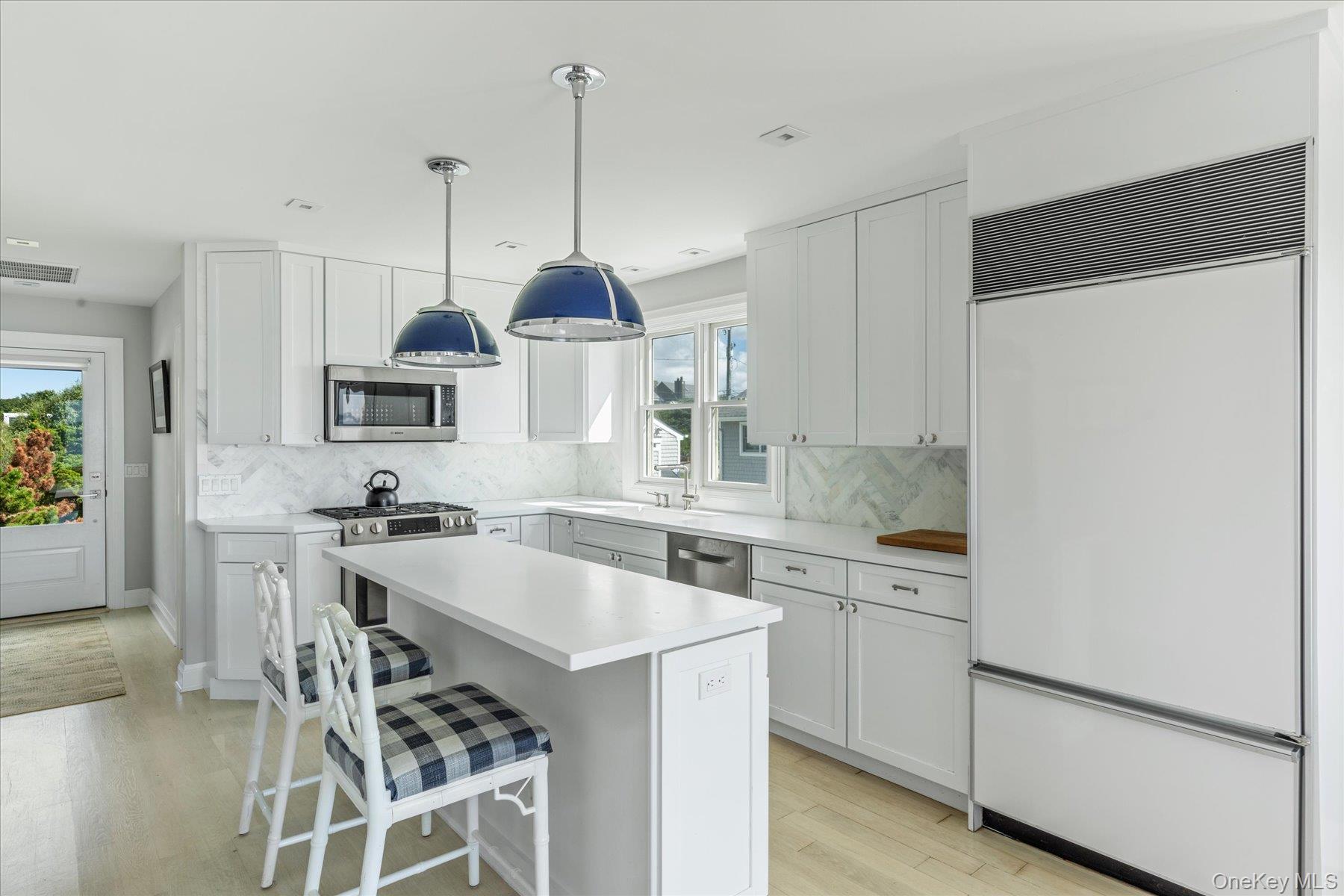 4415 Camp Mineola Road Mattituck, NY 11952 - Photo 10 of 44 Updated custom kitchen with stainless steel appliances, sleek white cabinetry and quartz countertops.