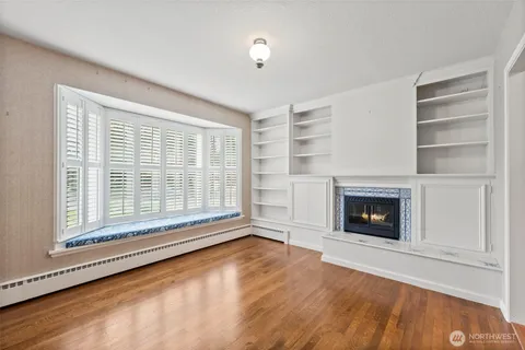 a view of an empty room with a fireplace and a window