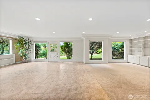 a view of a room with windows and tree in front of it