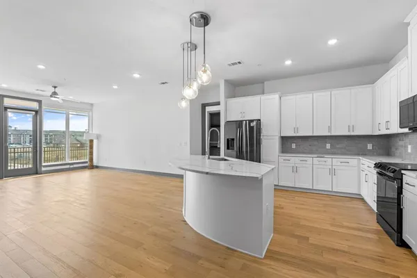 a kitchen with stainless steel appliances granite countertop a stove and a wooden floors