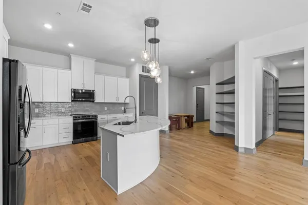 a kitchen with a center island appliances and cabinets
