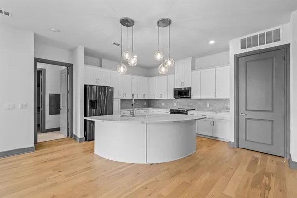 a kitchen with kitchen island a sink appliances and cabinets