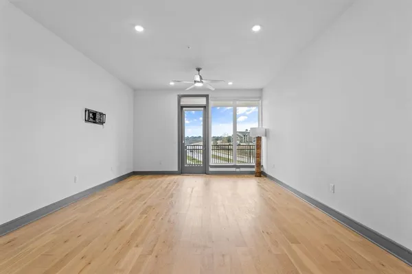 an empty room with a window and a fan