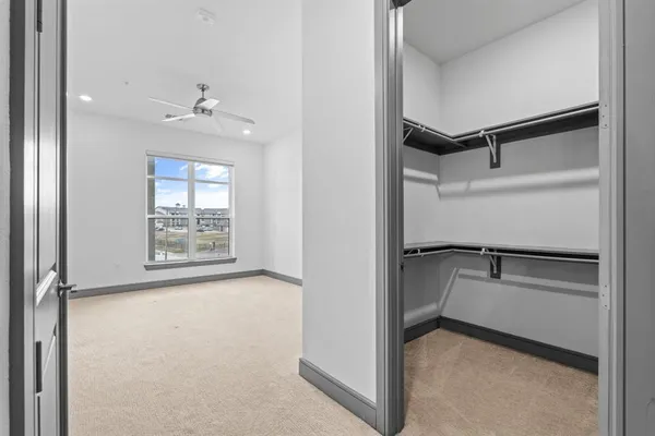 an empty room with a ceiling fan and entryway