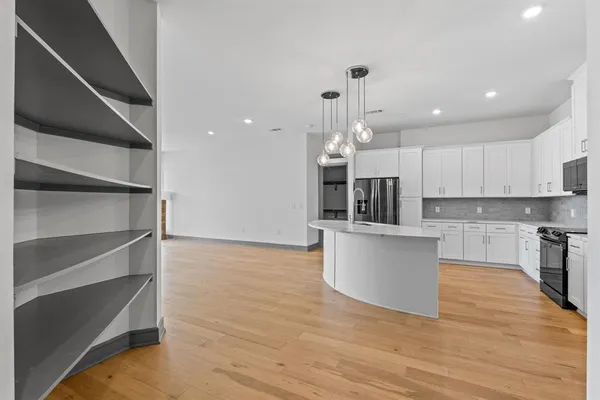 a large kitchen with stainless steel appliances granite countertop a stove and a sink
