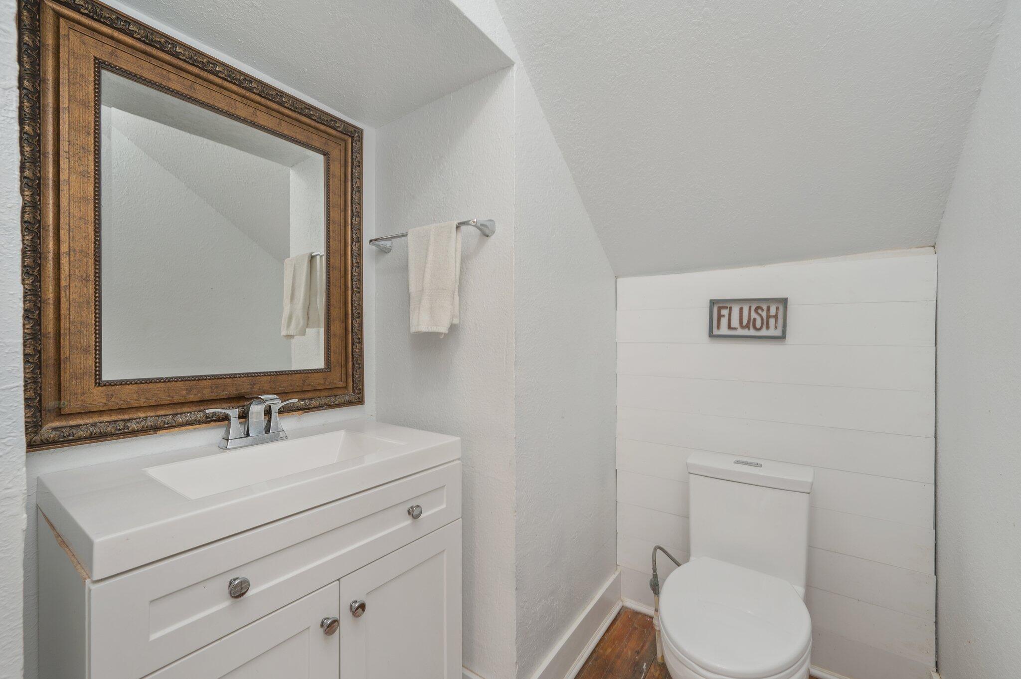 938 5th Street Florala, AL 36442 - Photo 28 of 65 a bathroom with a toilet a sink and mirror
