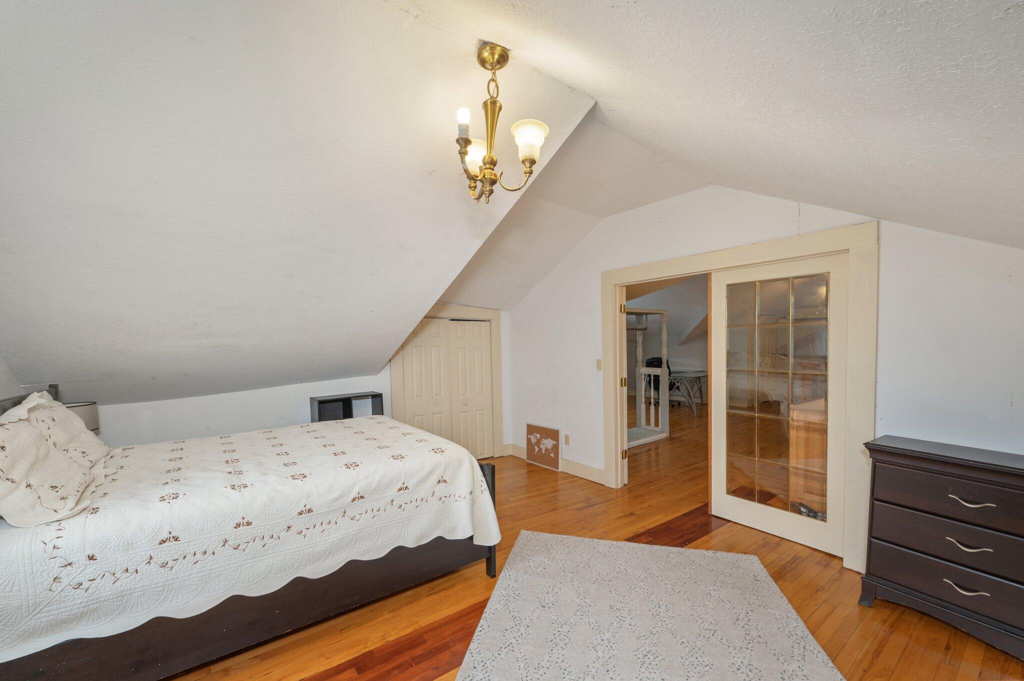 938 5th Street Florala, AL 36442 - Photo 39 of 65 a bedroom with a large bed and a chandelier