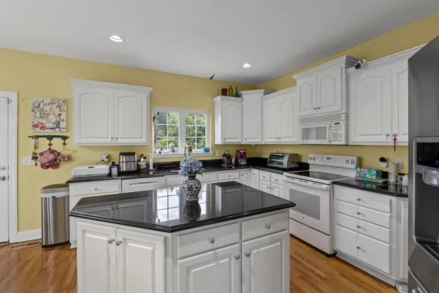 a kitchen with granite countertop a sink a stove and cabinets