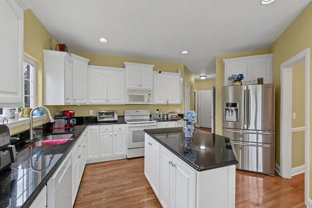 a kitchen with a refrigerator a sink and a stove top oven