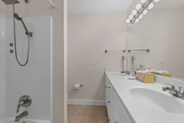 a bathroom with a granite countertop sink a mirror and shower