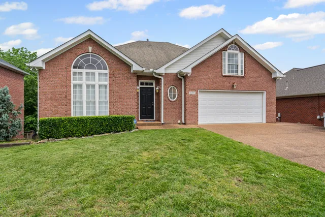 a front of a house with a yard and garage
