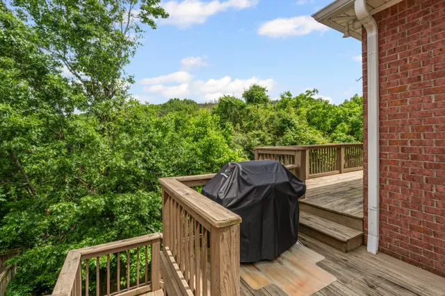 a view of a house with a yard porch and wooden fence