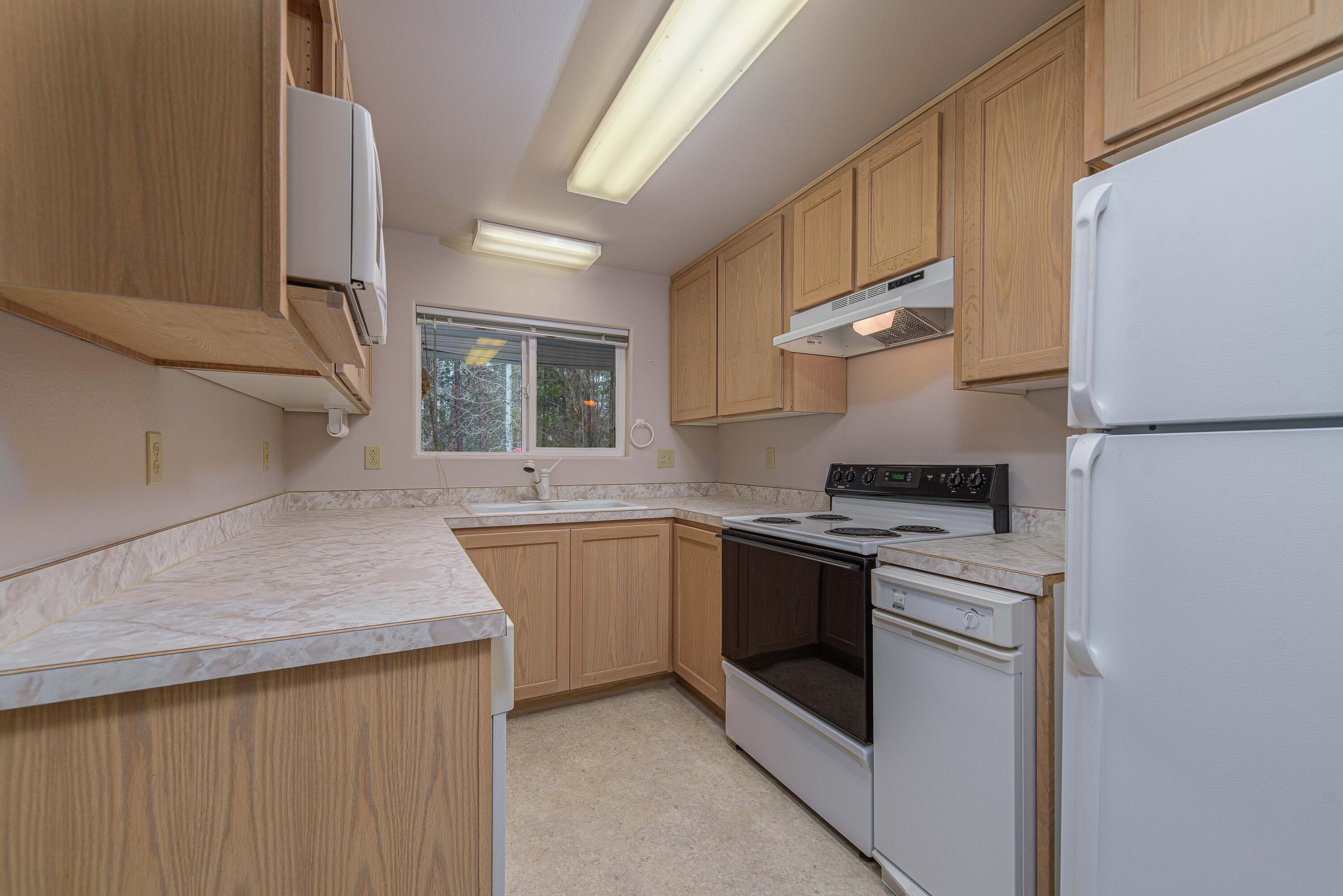 138722 Rhododendron Street Gilchrist, OR 97737 - Photo 17 of 36 a kitchen with stainless steel appliances granite countertop a sink stove and refrigerator