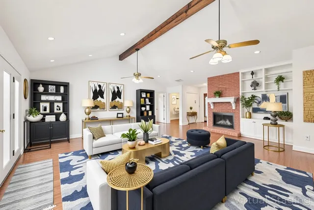 a living room with furniture kitchen view and a wooden floor