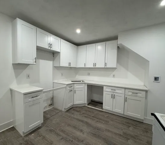 a kitchen with a sink cabinets and wooden floor