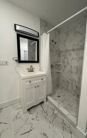 a bathroom with a sink mirror and a shower