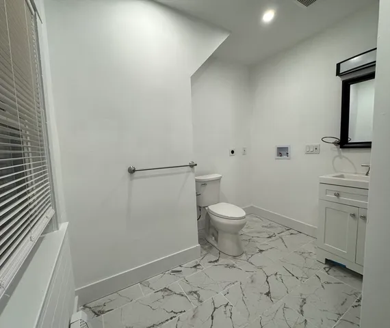 a bathroom with a toilet sink and mirror