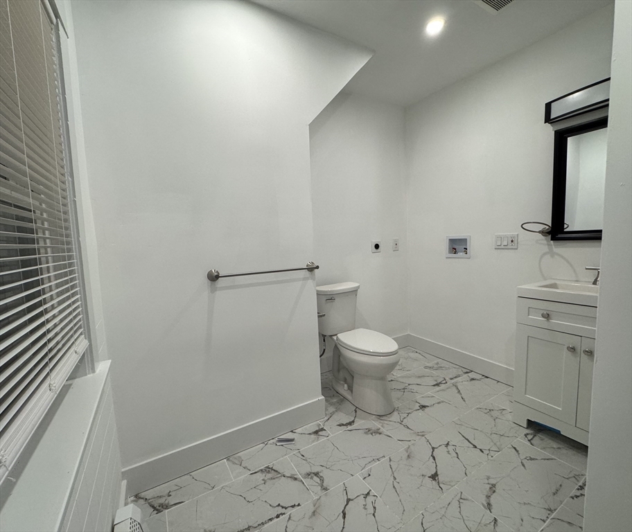 120 Sea Street, Unit A Barnstable, MA 02601 - Photo 6 of 6 a bathroom with a toilet sink and mirror