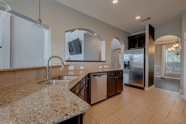 a kitchen with stainless steel appliances granite countertop a sink and a refrigerator