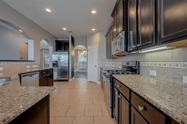 a kitchen with stainless steel appliances granite countertop a sink and stove
