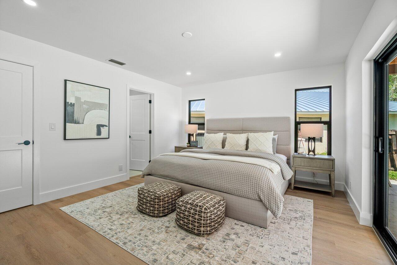 4408 Nicole Circle Tequesta, FL 33469 - Photo 17 of 29 a bedroom with a bed and wooden floor