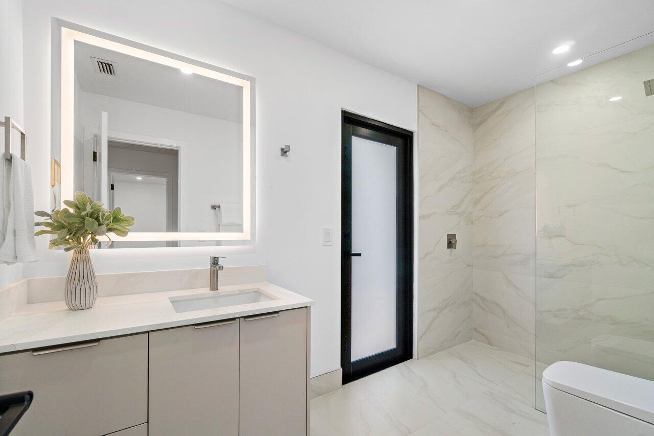 4408 Nicole Circle Tequesta, FL 33469 - Photo 20 of 29 a bathroom with a shower sink and mirror