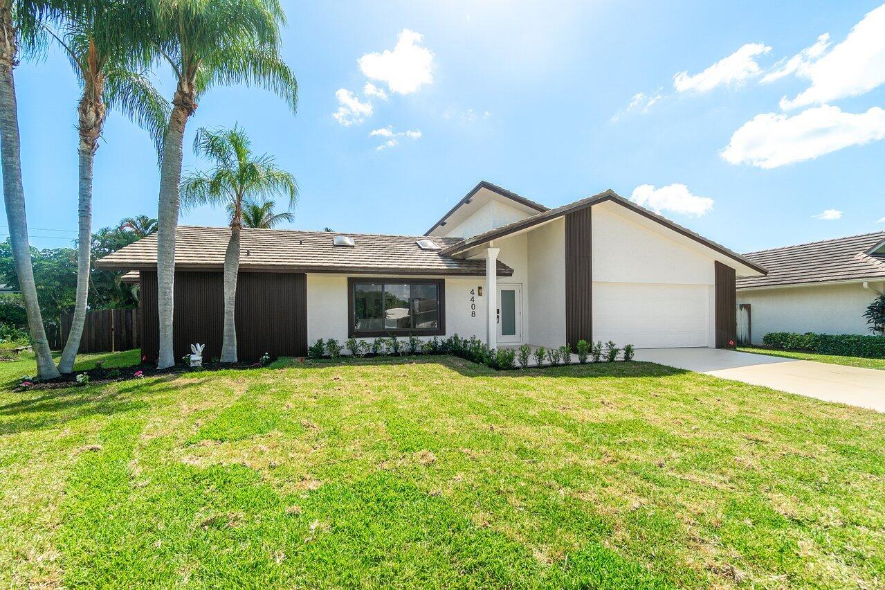 4408 Nicole Circle Tequesta, FL 33469 - Photo 2 of 29 a view of a house with a yard and palm trees