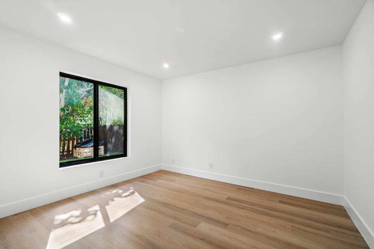 4408 Nicole Circle Tequesta, FL 33469 - Photo 21 of 29 an empty room with wooden floor and windows