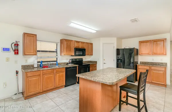 a kitchen with stainless steel appliances granite countertop a stove top oven a sink dishwasher and a refrigerator
