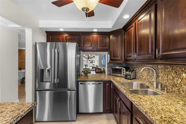 a kitchen with stainless steel appliances granite countertop a sink and a refrigerator