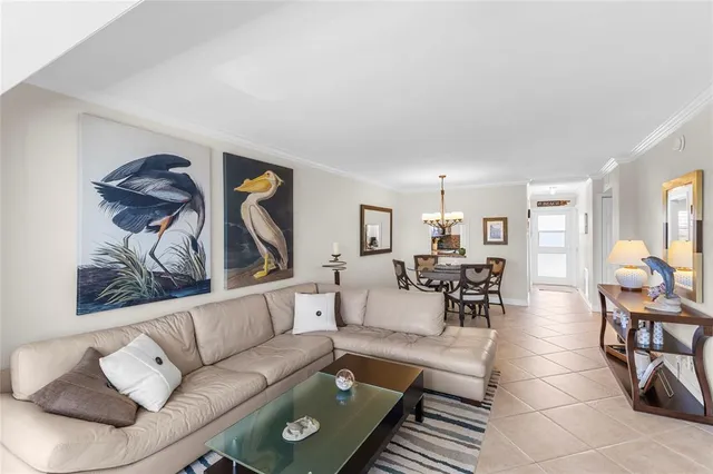 a living room with furniture chandelier and a table