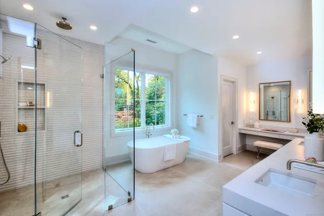 a bathroom with a tub a shower and a sink